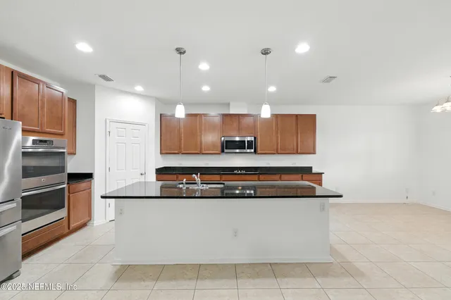 a large kitchen with stainless steel appliances and a refrigerator