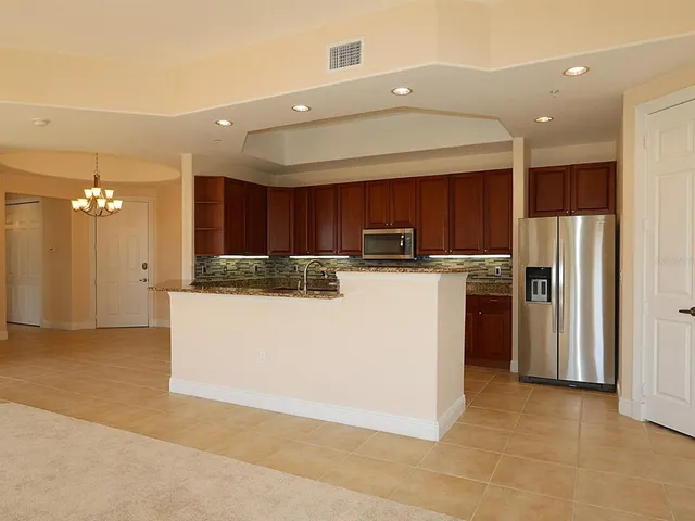 a kitchen with stainless steel appliances granite countertop a refrigerator a sink and a stove