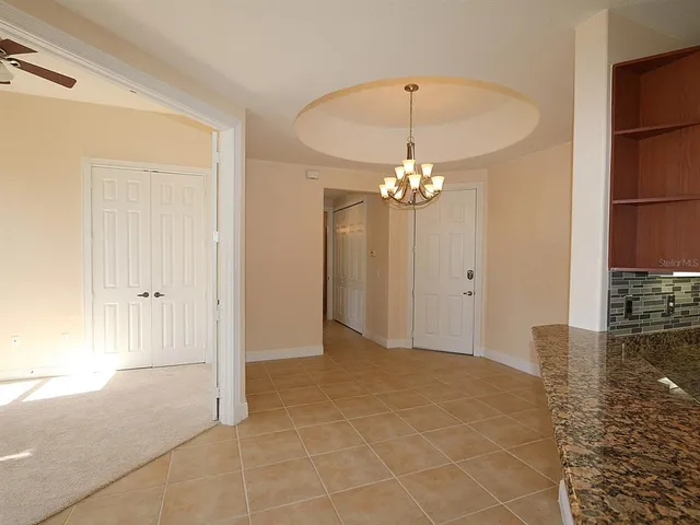 a view of a chandelier in big room and a bathroom