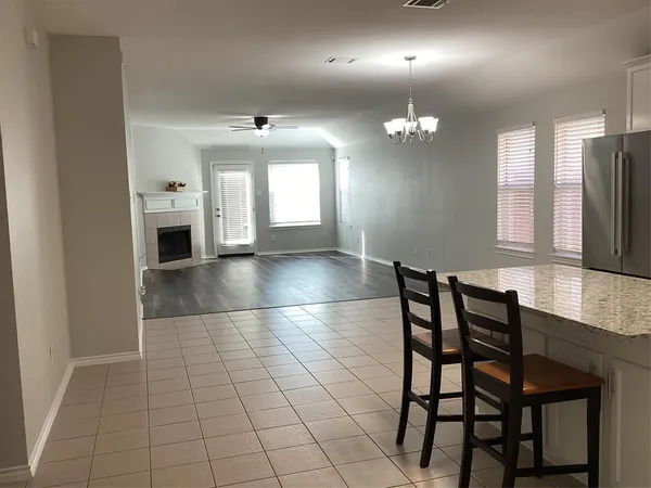 an empty room with chandelier fan and windows
