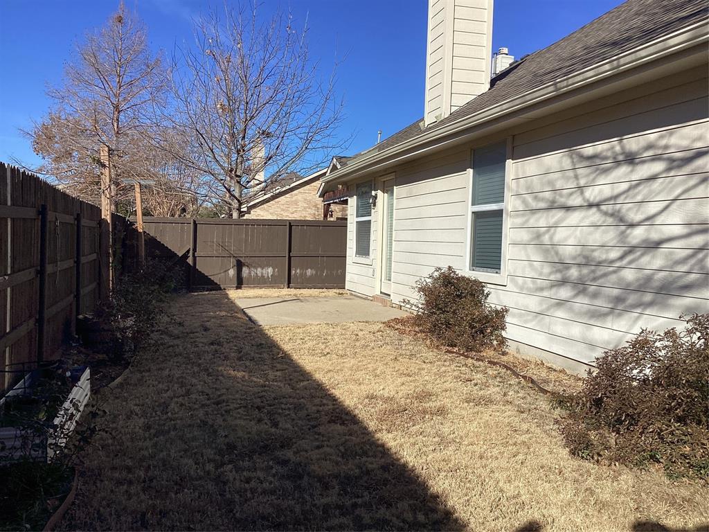 4608 Wolf Ridge Way Fort Worth, TX 76244 - Photo 22 of 23 a backyard of a house with large trees and wooden fence