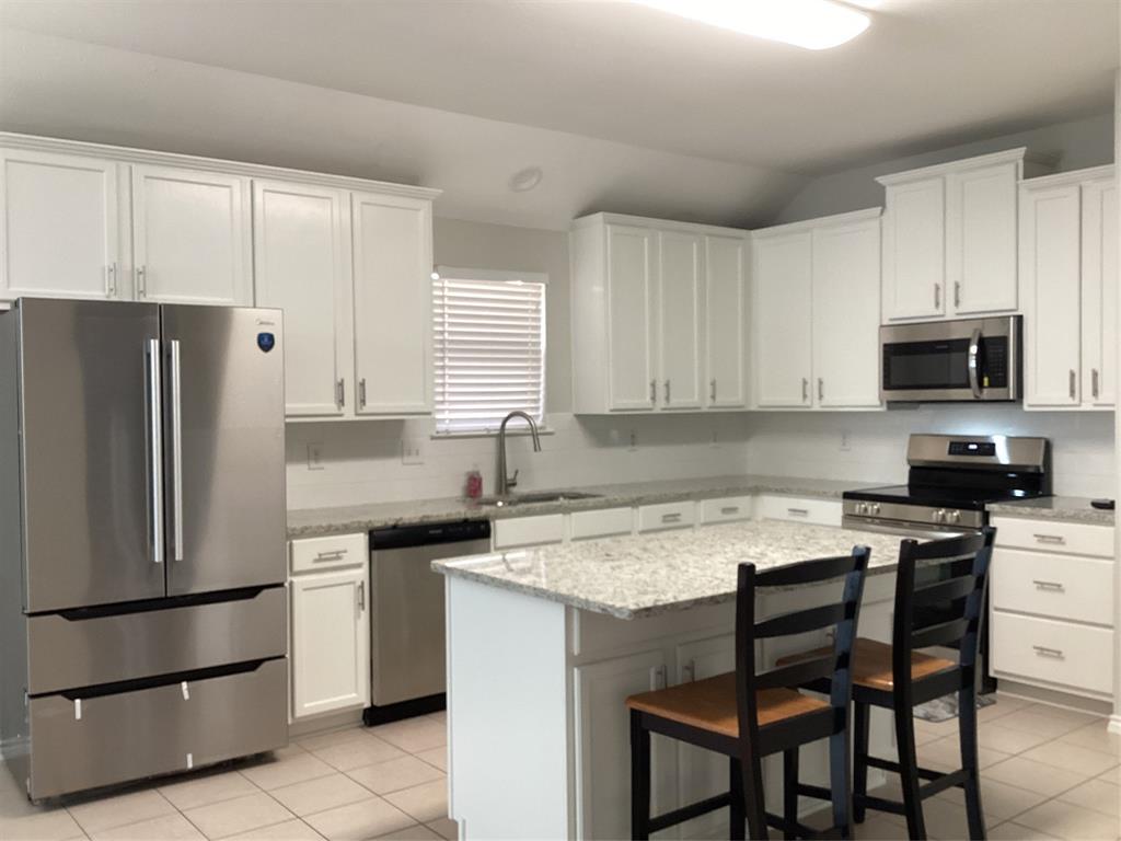 4608 Wolf Ridge Way Fort Worth, TX 76244 - Photo 3 of 23 a kitchen with a stove a sink and a refrigerator