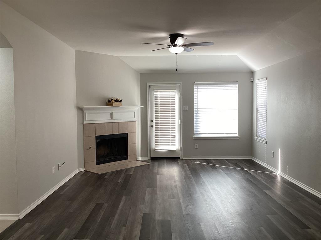 4608 Wolf Ridge Way Fort Worth, TX 76244 - Photo 7 of 23 an empty room with wooden floor fireplace and windows