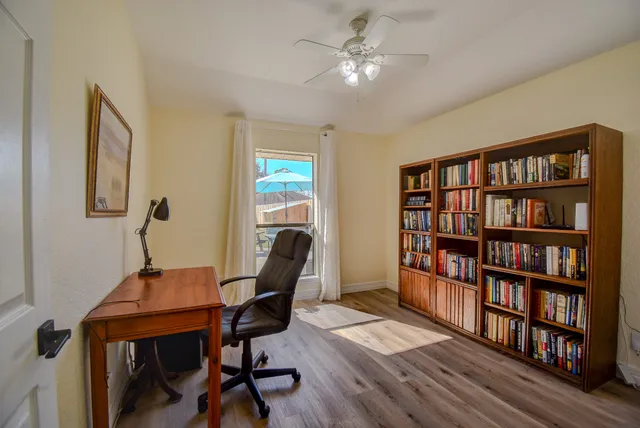 a view of a workspace with furniture and a bookshelf