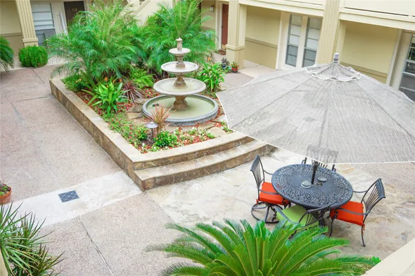 a table and chairs in a patio with potted plants