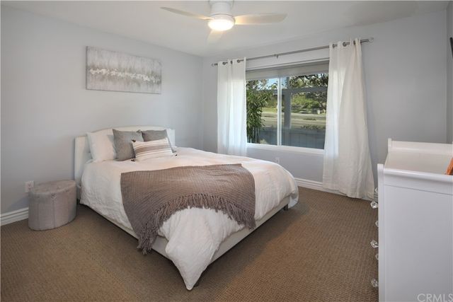 a bedroom with a bed and a large window