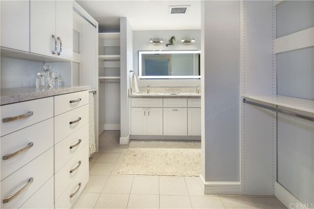 a kitchen with white cabinets and window