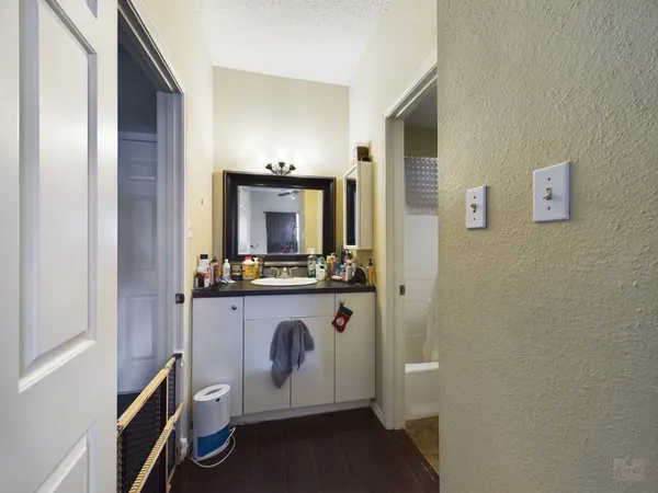 a bathroom with a sink a mirror and wooden floor