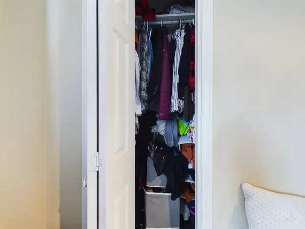 a view of walk in closet with clothes and shoes