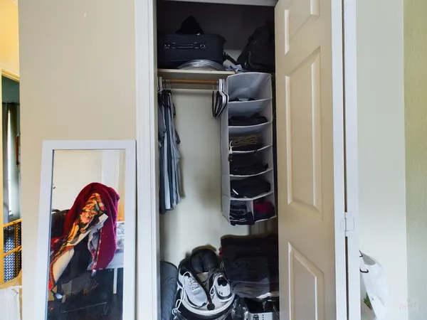 a view of walk in closet with clothes and shoes