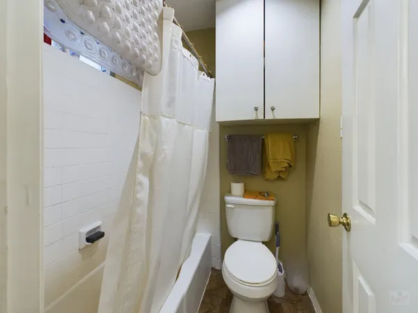 a white toilet sitting next to a shower