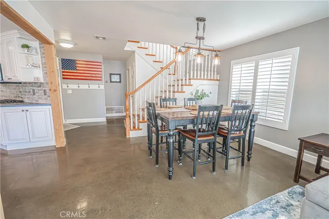 a kitchen with stainless steel appliances granite countertop a table and chairs in it