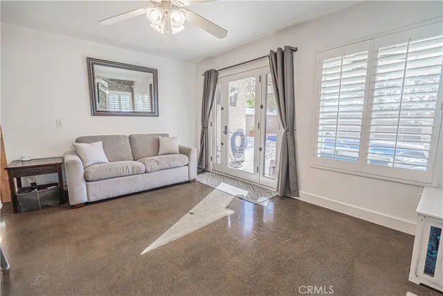 a living room with stainless steel appliances furniture a fireplace and a flat screen tv