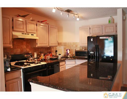 34 Inverness Drive Edison, NJ 08820 - Photo 5 of 16 a kitchen with stainless steel appliances granite countertop a stove a refrigerator a sink and dishwasher with wooden floor