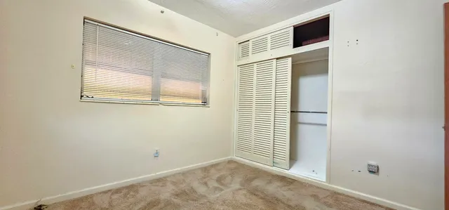 a view of a small space with wooden floor and a window