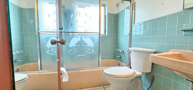 a bathroom with a sink a toilet and shower