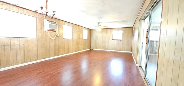 a view of a big room with wooden floor and windows