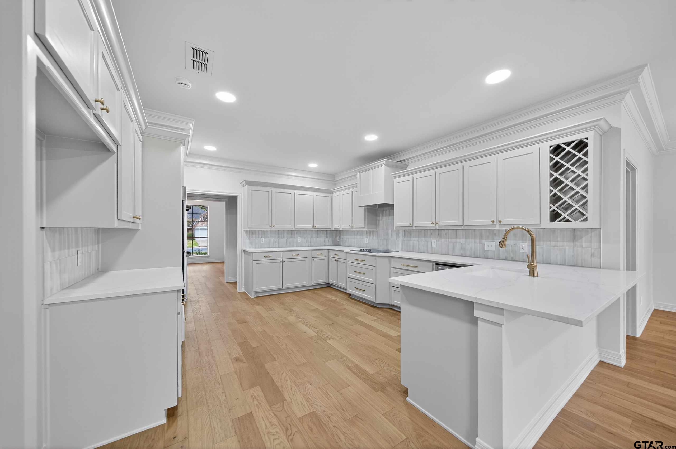 3409 Pebblebrook Drive Tyler, TX 75707 - Photo 11 of 48 a kitchen with white cabinets and white appliances