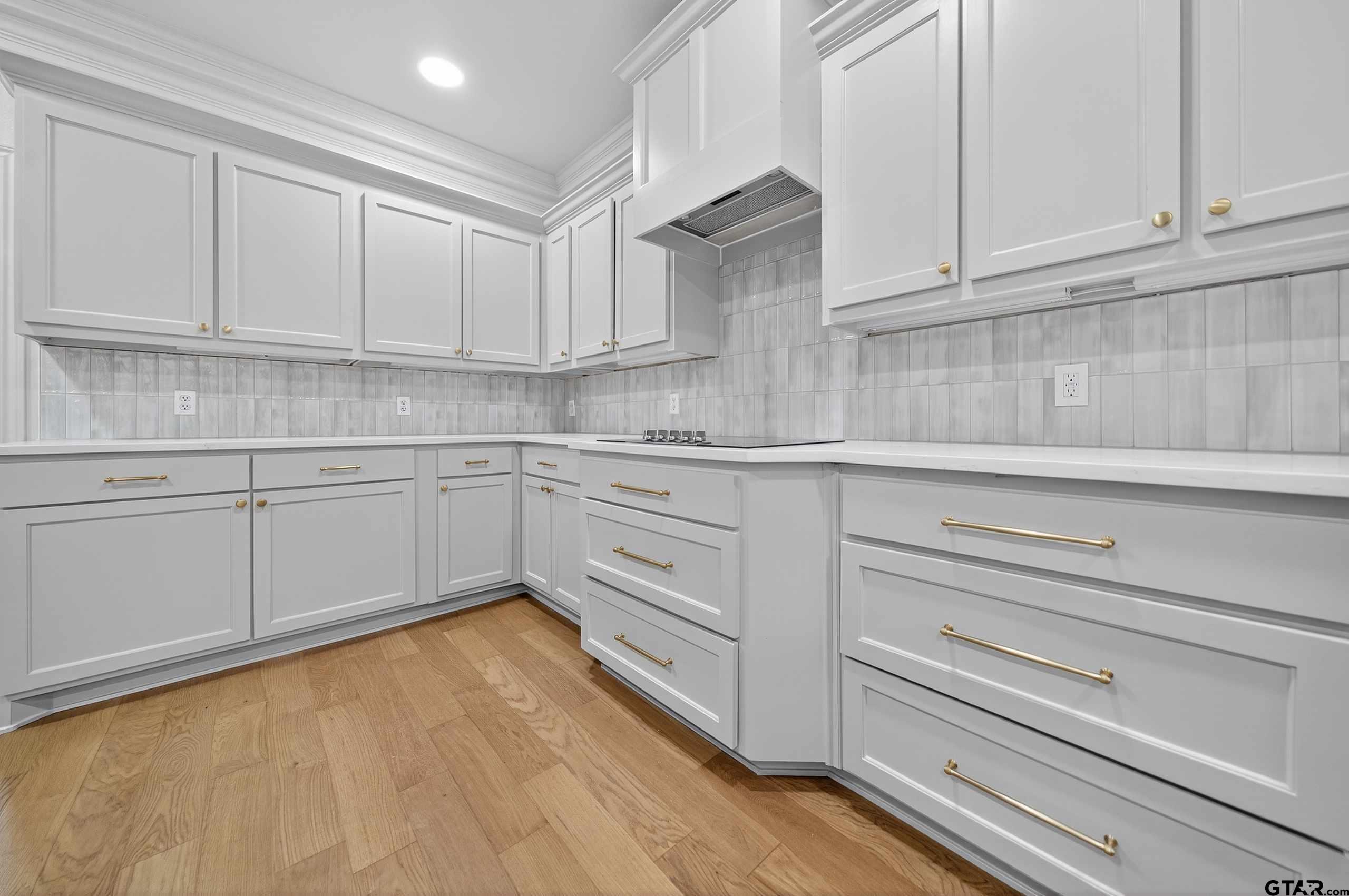 3409 Pebblebrook Drive Tyler, TX 75707 - Photo 14 of 48 a kitchen with white cabinets and sink