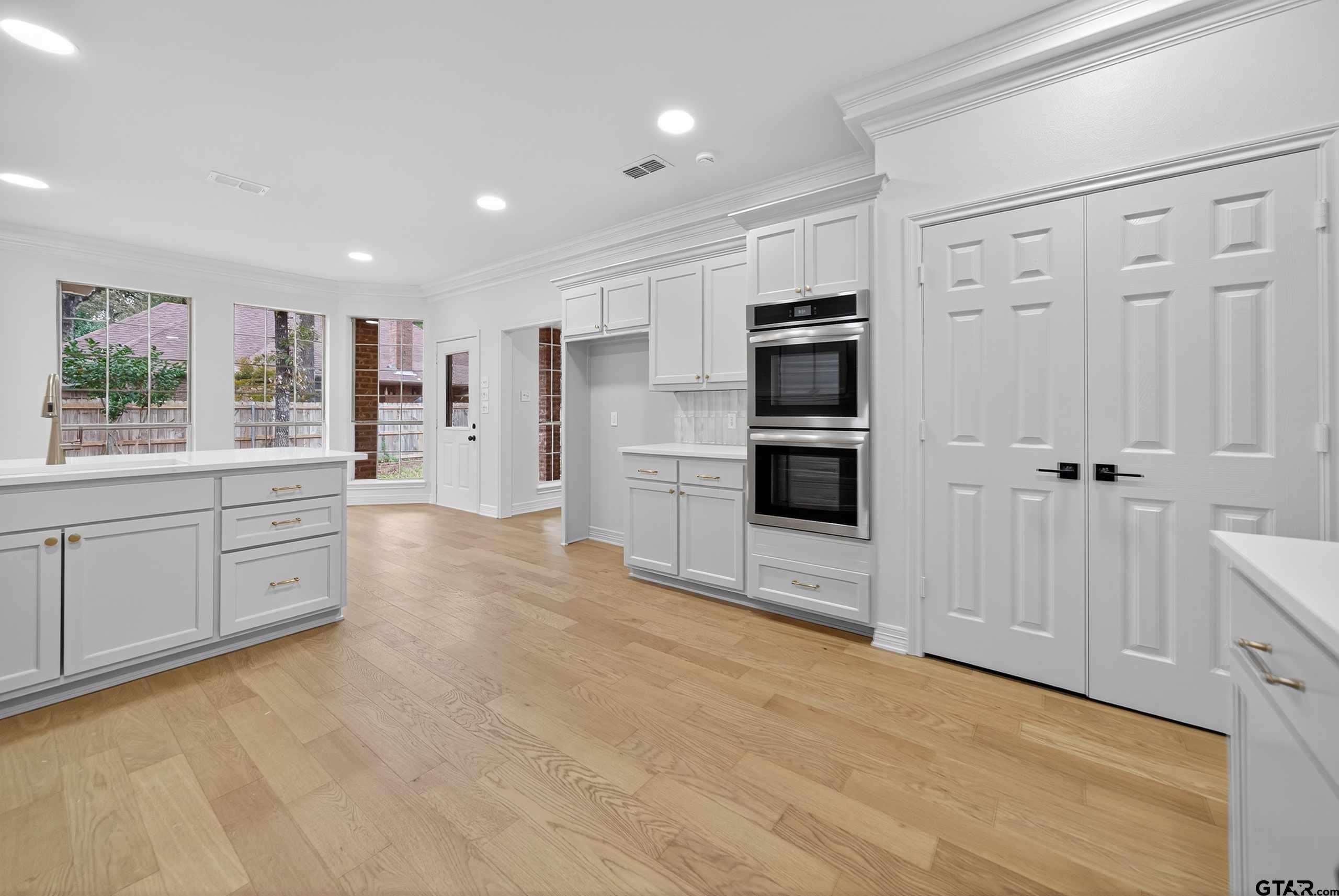 3409 Pebblebrook Drive Tyler, TX 75707 - Photo 15 of 48 a large white kitchen with stainless steel appliances