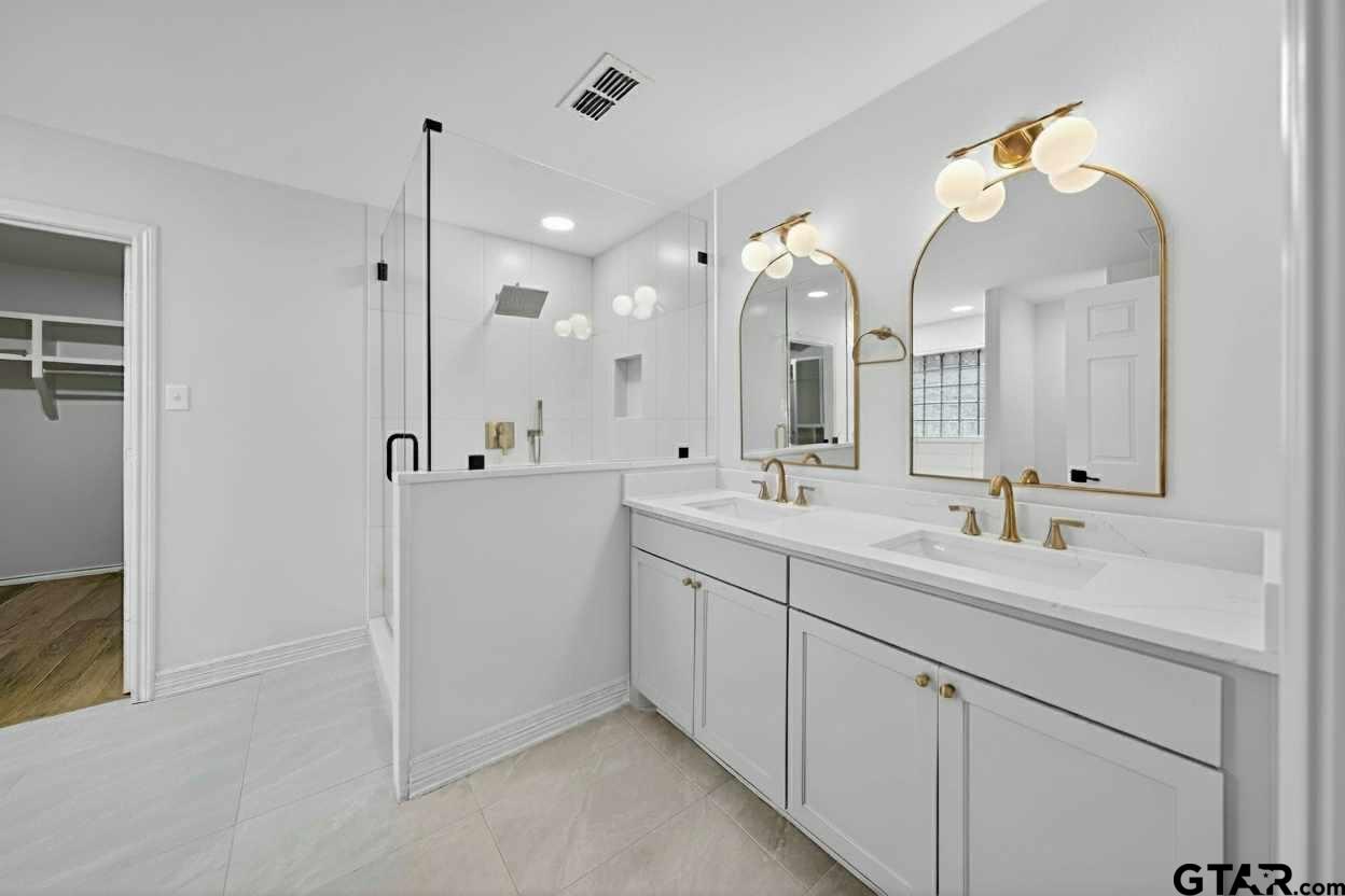 3409 Pebblebrook Drive Tyler, TX 75707 - Photo 20 of 48 a spacious bathroom with a double vanity sink mirror and double
