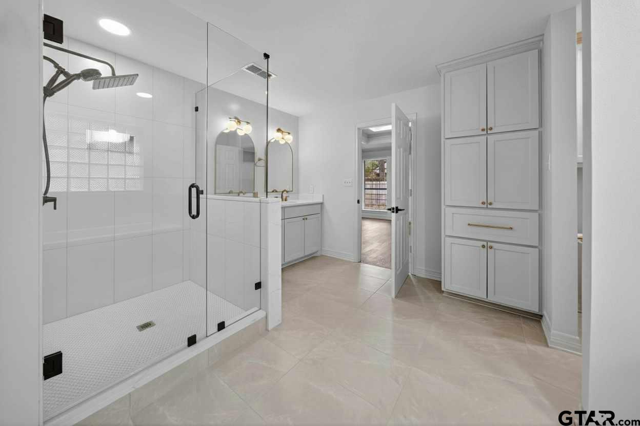 3409 Pebblebrook Drive Tyler, TX 75707 - Photo 21 of 48 a bathroom with a shower and a tub