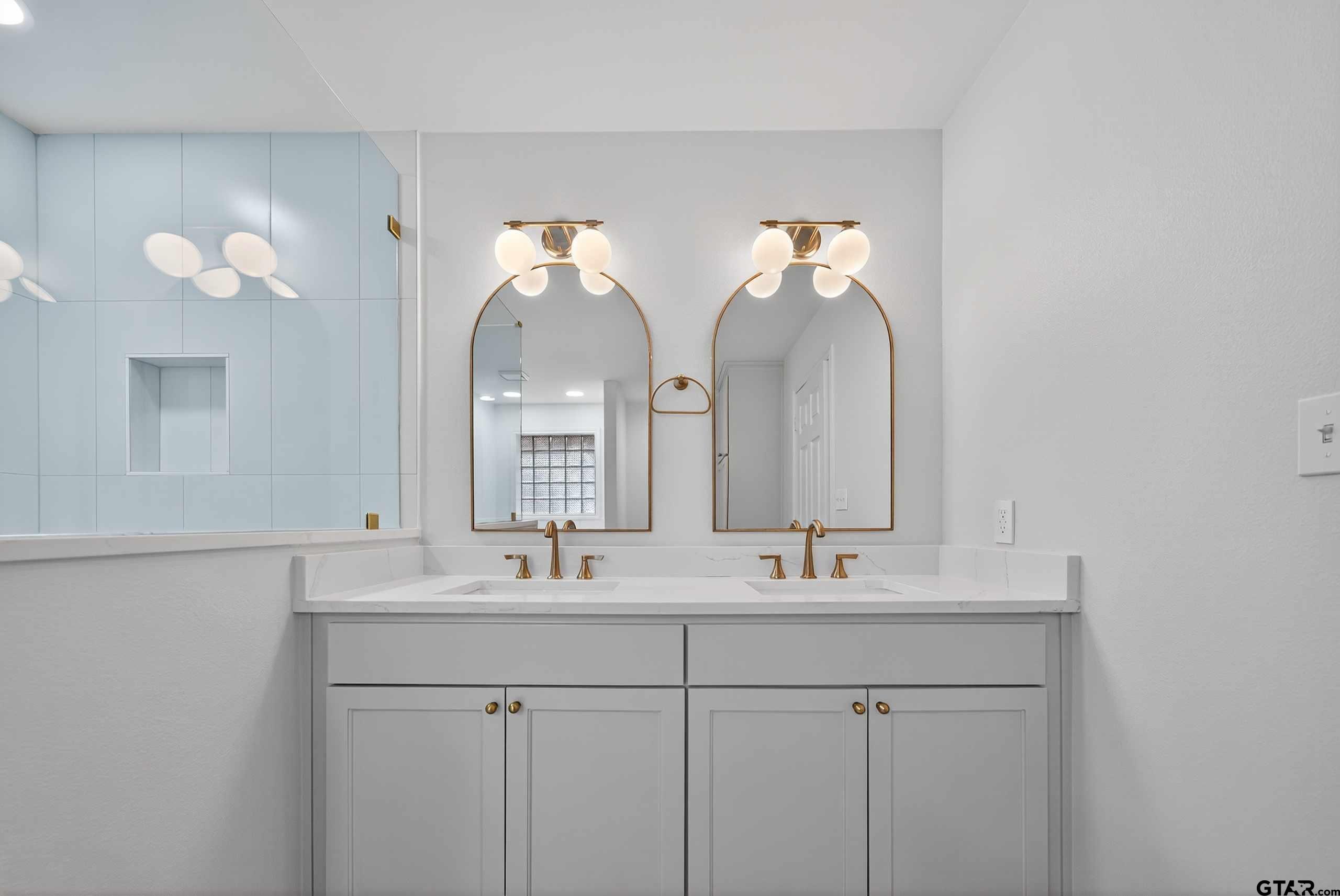 3409 Pebblebrook Drive Tyler, TX 75707 - Photo 23 of 48 a bathroom with double vanity sinks and a mirror