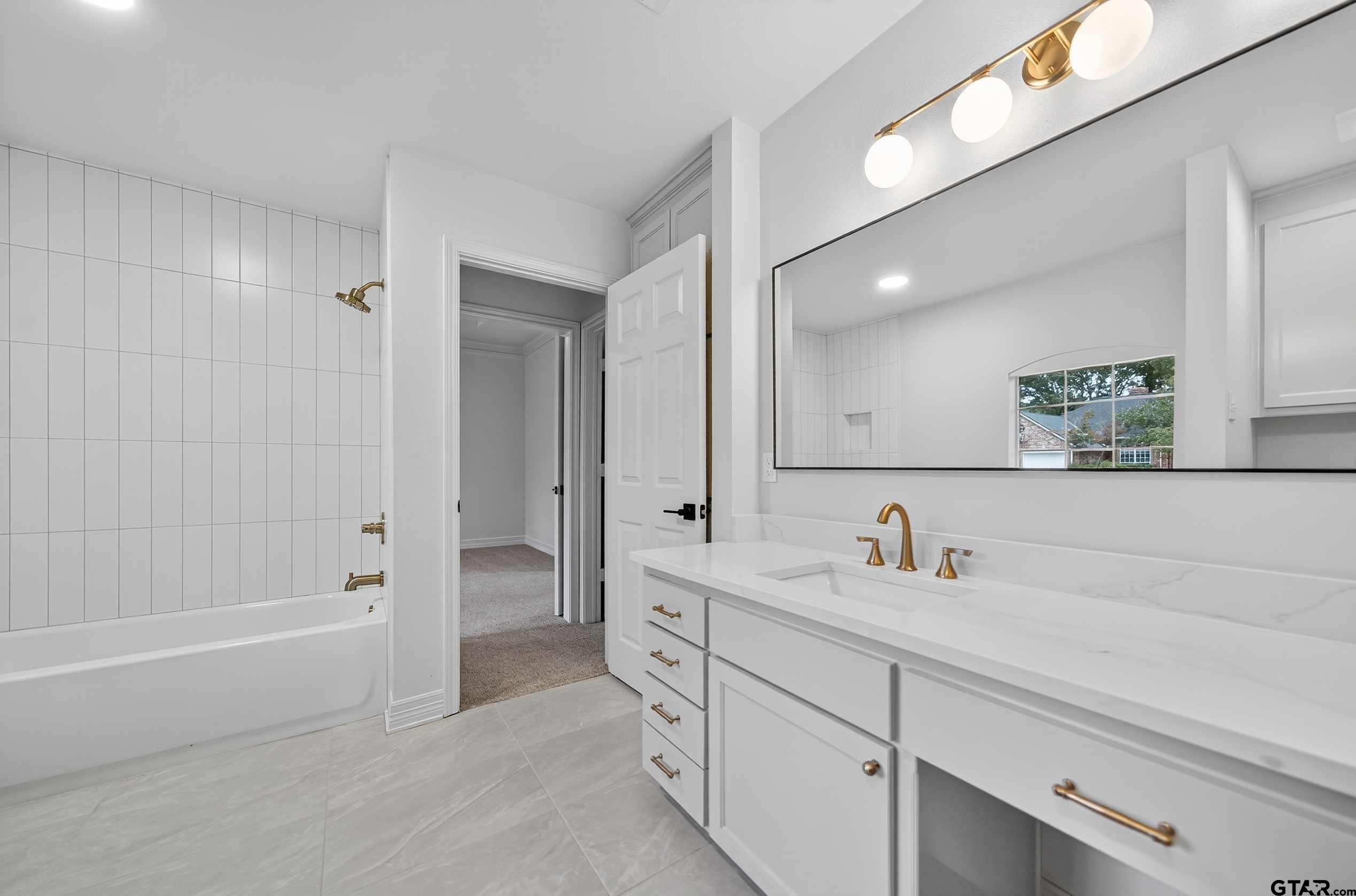 3409 Pebblebrook Drive Tyler, TX 75707 - Photo 29 of 48 a spacious bathroom with a tub sink a mirror and a shower