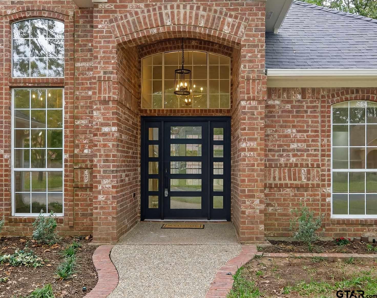 3409 Pebblebrook Drive Tyler, TX 75707 - Photo 3 of 48 a front view of a house with a garden