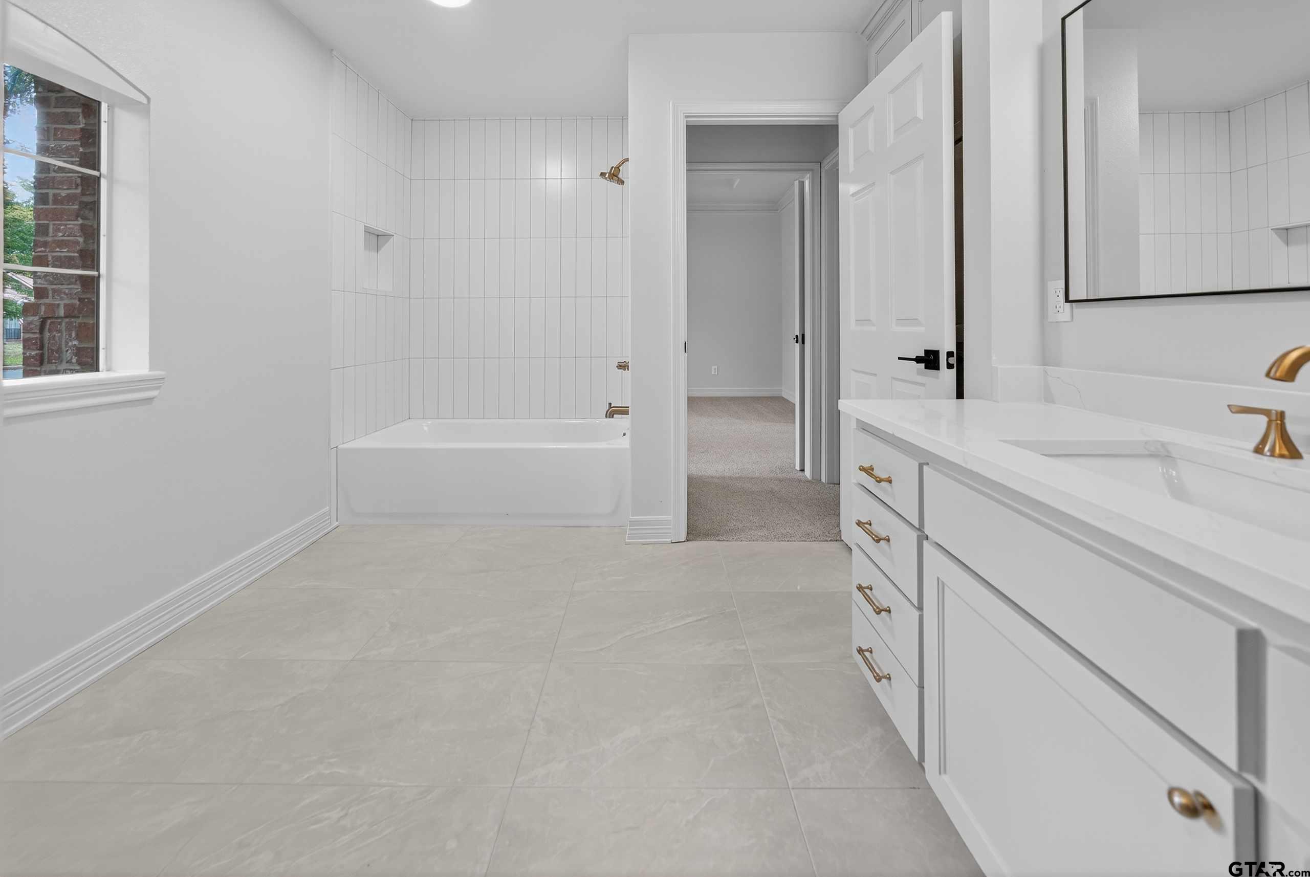 3409 Pebblebrook Drive Tyler, TX 75707 - Photo 31 of 48 a spacious bathroom with a tub sink and mirror