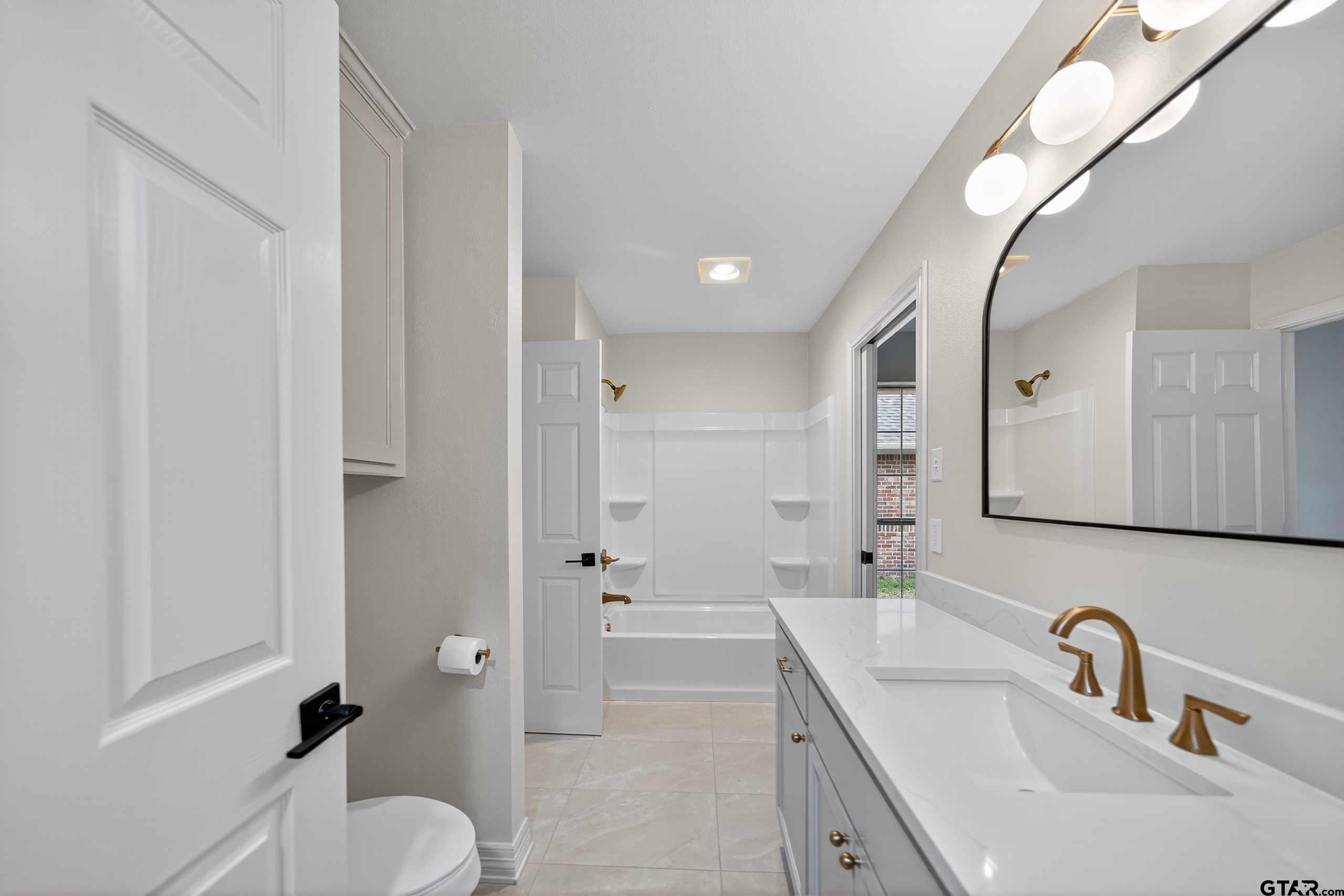 3409 Pebblebrook Drive Tyler, TX 75707 - Photo 39 of 48 a bathroom with a sink a toilet and shower