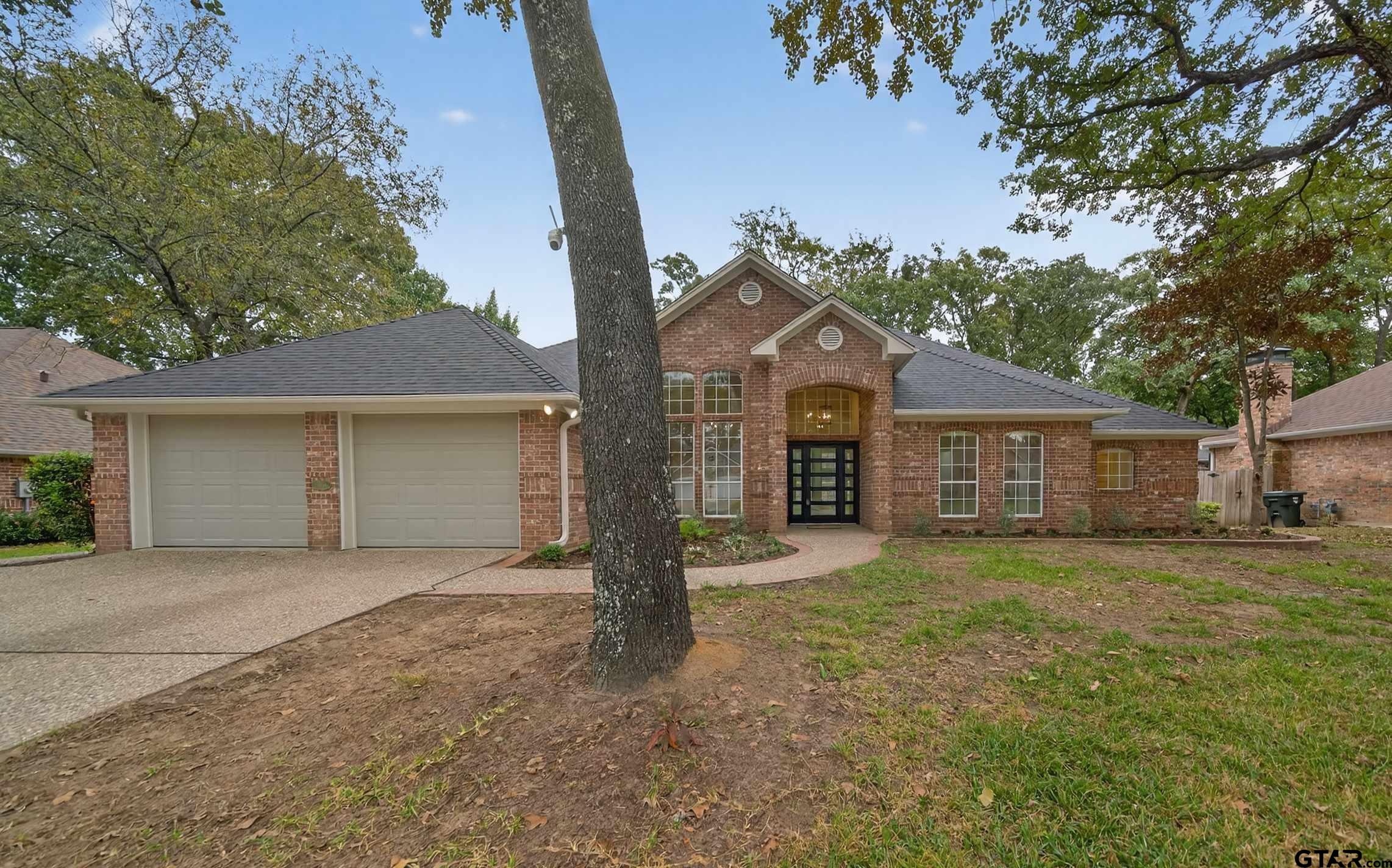 3409 Pebblebrook Drive Tyler, TX 75707 - Photo 4 of 48 a front view of a house with a yard and garage