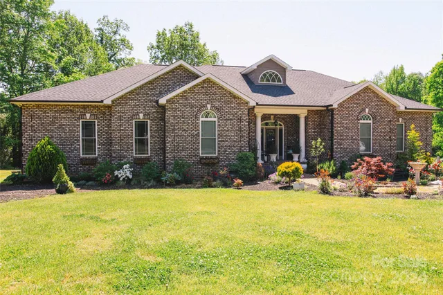 a view of a house with patio and a yard