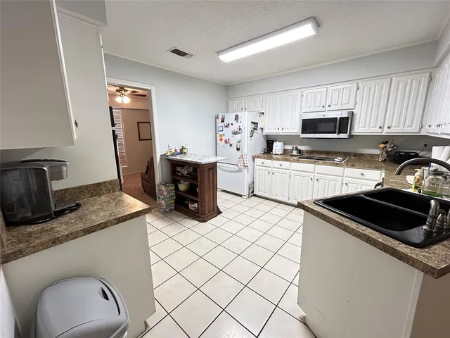 a kitchen with stainless steel appliances granite countertop a sink stove refrigerator and cabinets