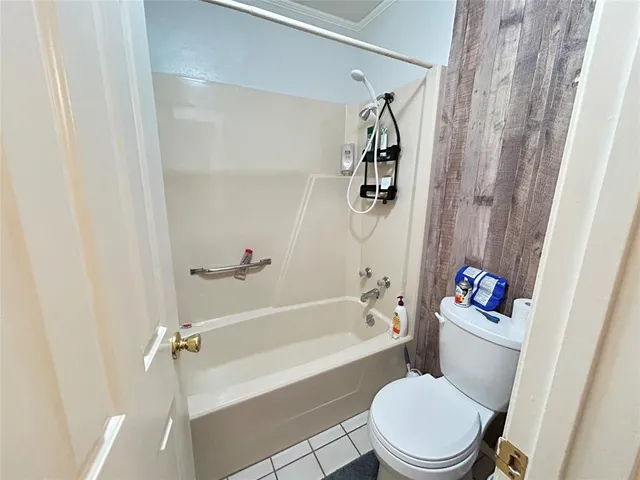 a white toilet and tub sitting next to a shower