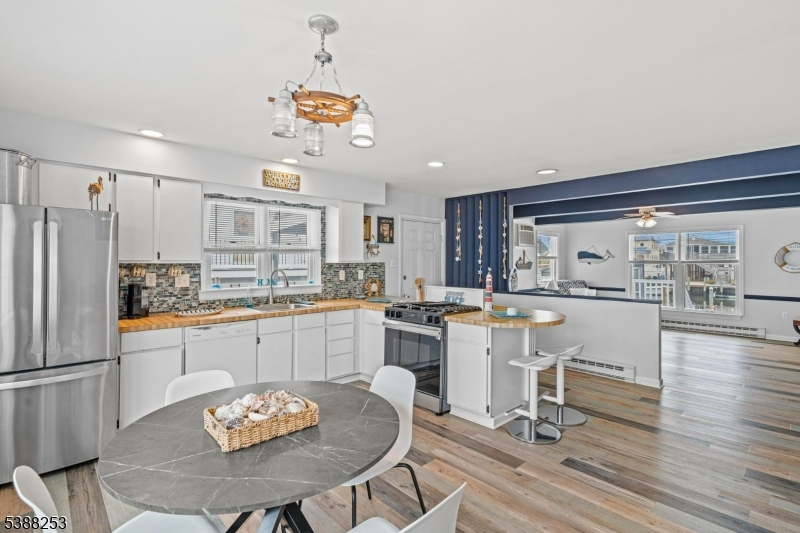 112 Curlew Road Tuckerton, NJ 08087 - Photo 4 of 20 a kitchen with a dining table chairs and refrigerator