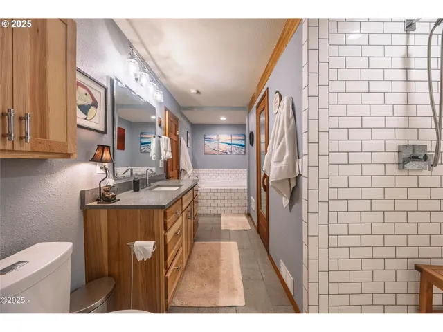 a bathroom with a granite countertop sink a toilet and a mirror