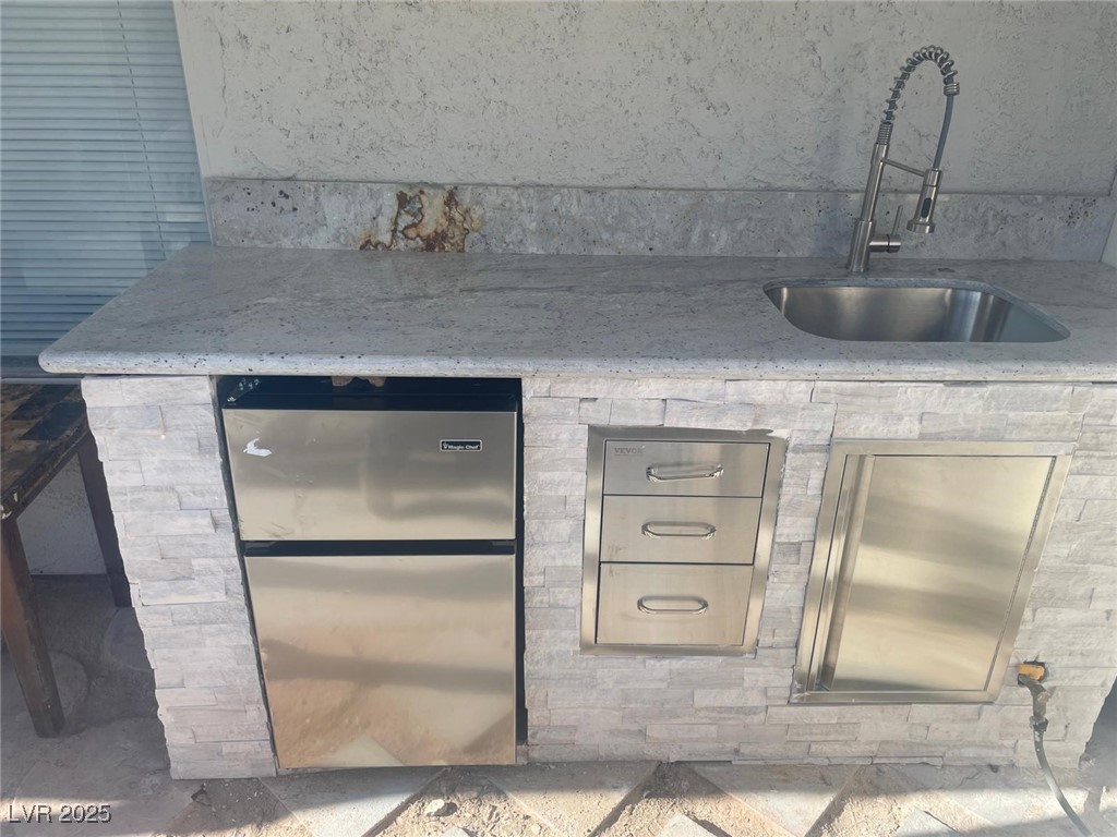 5415 Oxbow Street Las Vegas, NV 89119 - Photo 16 of 20 Kitchen featuring freestanding refrigerator and light stone counters