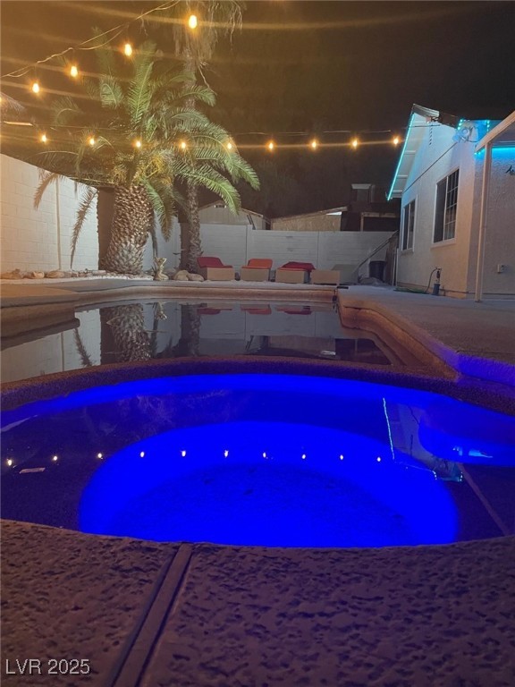 5415 Oxbow Street Las Vegas, NV 89119 - Photo 18 of 20 Pool at night with a fenced backyard, a hot tub, and a patio