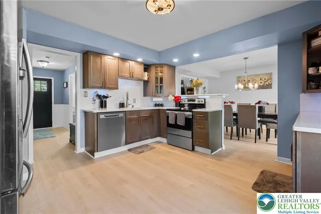 a kitchen with stainless steel appliances kitchen island granite countertop a refrigerator and a sink
