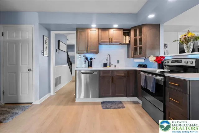 a kitchen with stainless steel appliances a sink stove and refrigerator