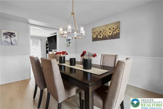 a view of a dining room with furniture a chandelier and wooden floor