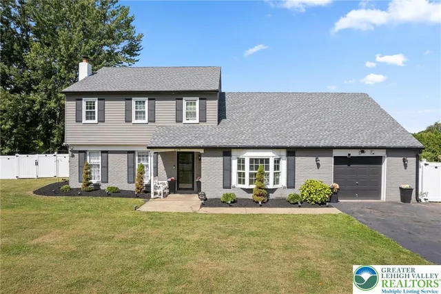 a front view of a house with garden and plants
