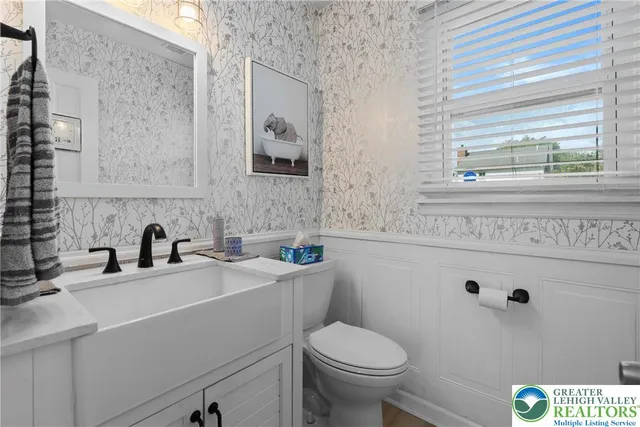 a bathroom with a sink a toilet and a mirror