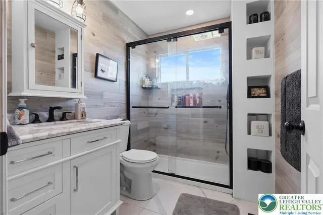 a bathroom with a granite countertop sink a toilet and shower
