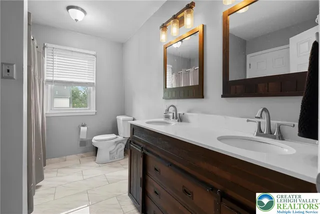 a bathroom with a sink double vanity and a toilet