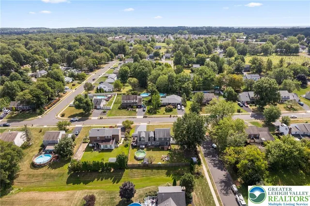 an aerial view of residential houses with outdoor space and swimming pool