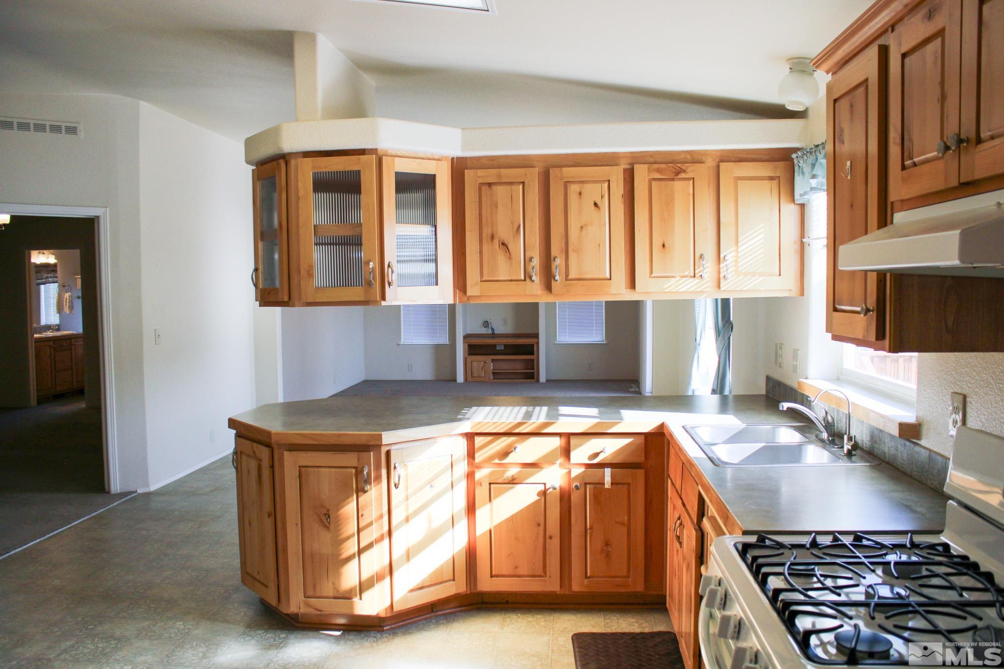 1850 Pam's Place Fallon, NV 89406 - Photo 14 of 40 a kitchen with stainless steel appliances granite countertop a sink stove and refrigerator