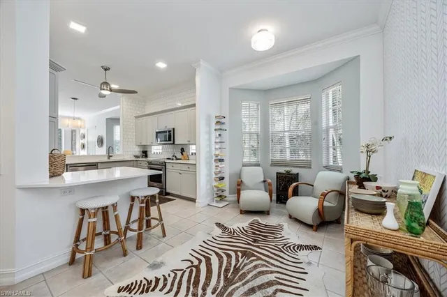 a living room with furniture kitchen view and a large window