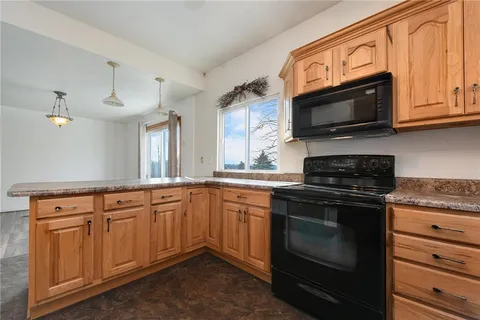 a kitchen with stainless steel appliances granite countertop a stove microwave and sink